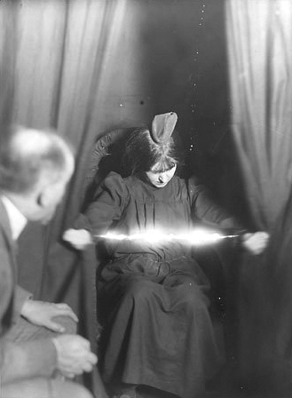 Światło rzekomo ukazujące się między rękoma medium, Evy Carrière; fotografia z 1912.  Albert von Schrenck-Notzing  (1862–1929)  - Wikipedia